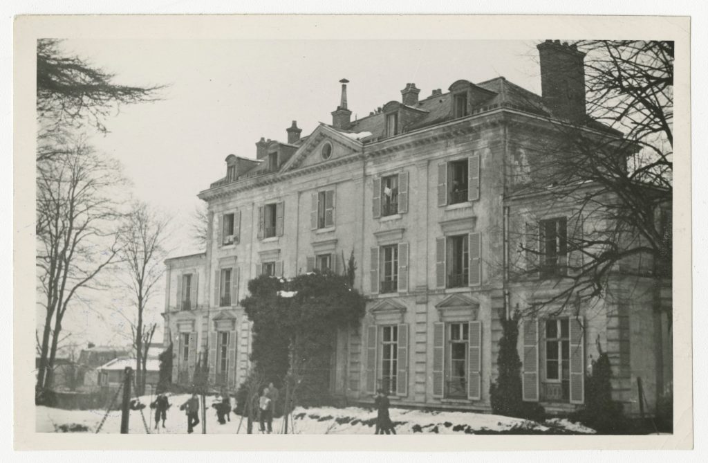 Building exterior in France, children playing in foreground